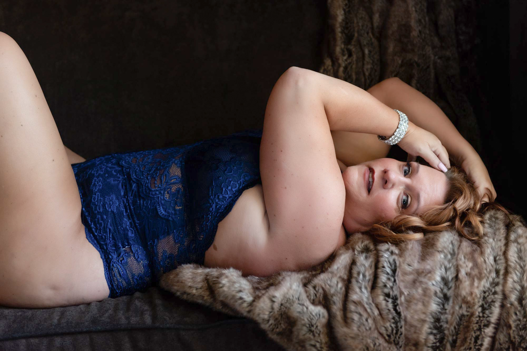 Boudoir photo of a woman in blue lingerie on a couch