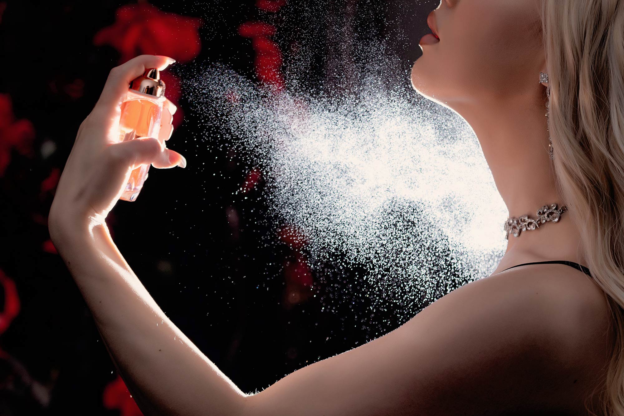 woman sprays perfume on her neck