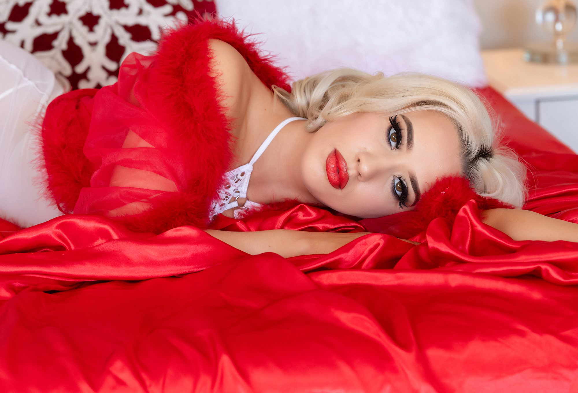 Gorgeous blonde woman on red satin sheets