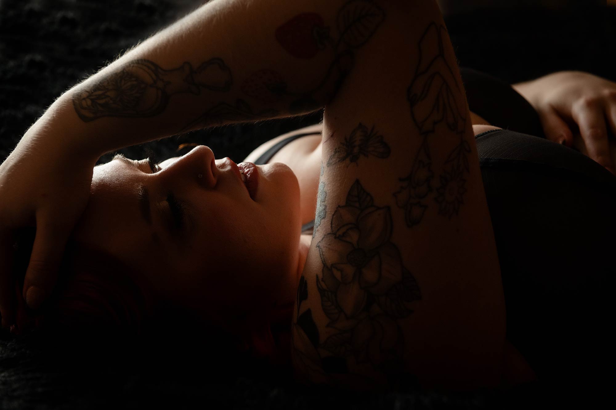 woman laying on bed with her hand on her head